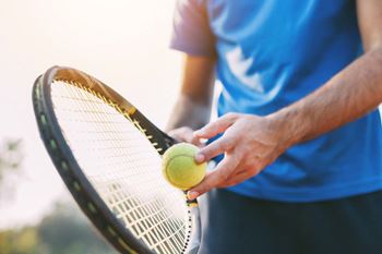 Man holding tennis racket and tennis ball ready to serve.at Fountains of Fair Oaks, Fair Oaks California